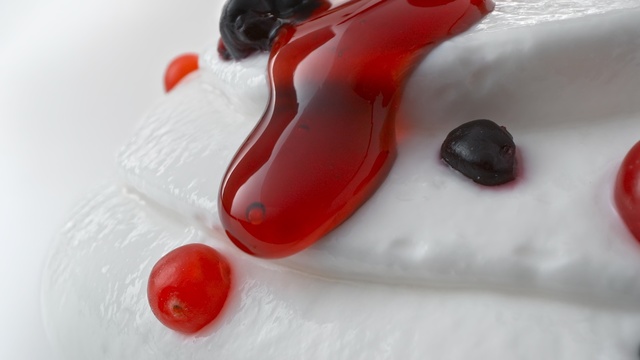 Video Reference: Red, Close-up, Wine gum, Food, Indoor, Table, Sitting, Plate, Cup, Small, Cake, Fruit, Piece, White, Snow, Spoon, Orange, Fork, Bowl, Pink, Holding, Dessert