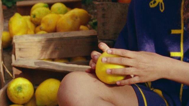 Video Reference: Local food, Natural foods, Fruit, Lemon, Food, Citrus, Plant, Citron, Peel, Produce, Person, Indoor, Table, Sitting, Holding, Man, Front, Banana, Eating, Plate, Apple, Boy, Young, Little, Woman, People, Phone, Kitchen, Standing, Vegetable, Diet food