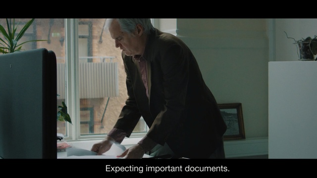 Video Reference: Human, Screenshot, Photo caption, Adaptation, Photography, Fictional character, Scene, Person, Man, Indoor, Standing, Front, Holding, Woman, Window, Monitor, Black, Table, Screen, Television, Suit, Suitcase, Room, Computer, Young, Playing, Luggage, Video, Remote, White, Board, Cat, Kitchen, Video game, Text, Human face, Clothing