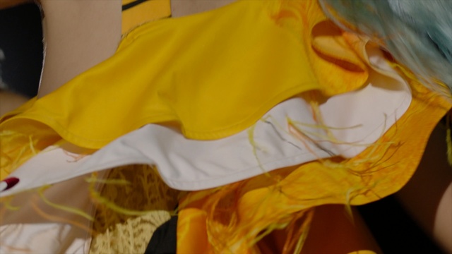 Video Reference: Yellow, Orange, Outerwear, T-shirt, Textile, Indoor, Sitting, Table, Small, Paper, Food, Bed, Laptop, Banana, Dog, Holding, Sandwich, Computer, Eating, Plate, White, Shirt, Stuffed, Fries, Cat