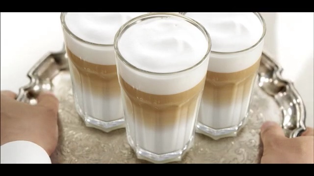 Video Reference: Drink, Latte macchiato, Food, Irish cream, Dairy, Alcoholic beverage, Milkshake, Cappuccino, Distilled beverage, Caffè macchiato, Cup, Table, Coffee, Glass, Ice, Beverage, Indoor, Sitting, Pitcher, Glasses, Dessert, Drinking, Cream, Water, Milk, Spoon, Tray, Small, Cake, Topped, Fruit, Half, Blender, Banana, Filled, Chocolate, Desert, Orange, Donut, Cut, Phone, Plate, Woman, Hot, Dog, White, Wedding, Coffee cup, Soft drink, Mug, Beer, Caffeine, Coffee milk, Drinkware, Pint glass, Latte, Tableware, Instant coffee, White coffee, Cortado, Cuban espresso, Meal