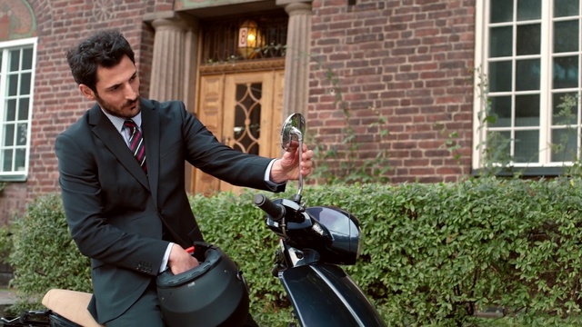 Video Reference: Suit, Scooter, Grass, Gentleman, Vehicle, Yard, Lawn, Plant, Garden