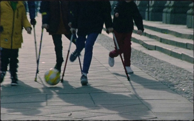 Video Reference: Walking, Footwear, Pedestrian, Recreation, Shadow, Ball, Stick and Ball Sports, Sports equipment, Leisure, Sidewalk