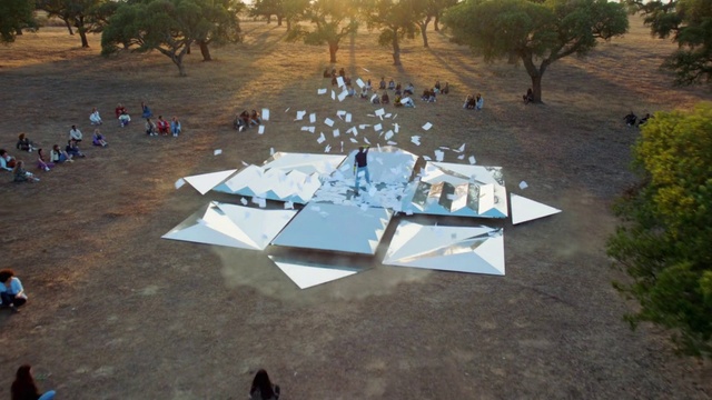 Video Reference: Tree, Architecture, Games, Recreation, Table, Leisure, Space, Sport venue, Urban design, Outdoor, Grass, Beach, Water, Park, People, Group, Sitting, Several, Bird, Sand, River, Walking, Airplane, Bench, Large, Field, Street, Standing, Dog, Playing, Parked, Man, Boat, Ground, Sandy