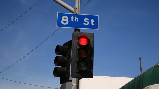 Video Reference: traffic light, signaling device, sky, light fixture, street sign, signage, sign, public utility, traffic sign, Person