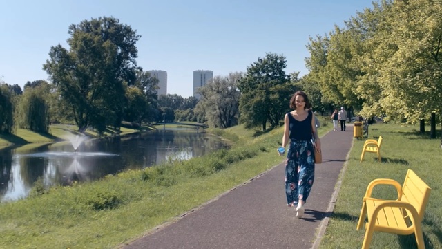 Video Reference: Water, Waterway, Tree, Yellow, Canal, River, Reflection, Bank, Spring, Walking, Person, Outdoor, Grass, Road, Man, Young, Woman, Park, Riding, Standing, Holding, Track, Street, Girl, Green, Board, Field, Doing, People, Sky, Clothing, Lake, Footwear, Plant