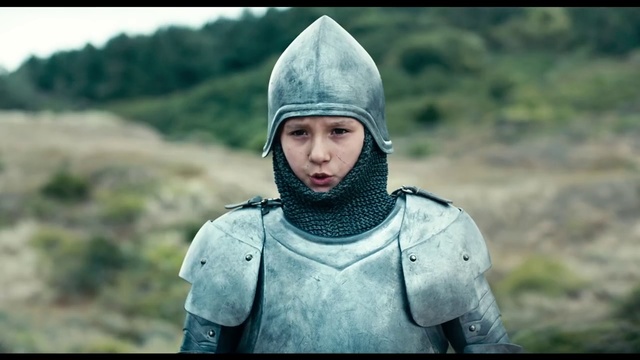 Video Reference: Helmet, Armour, Knight, Headgear, Screenshot, Personal protective equipment, Middle ages, Outdoor, Person, Grass, Clothing, Man, Wearing, Holding, Field, Standing, Uniform, Hat, Boy, Green, Young, Smiling, Little, Mountain, Walking, Riding, Woman, Blue, Shirt, Board, Head, White, Water, Red, Kite, Human face, Jacket, Armor