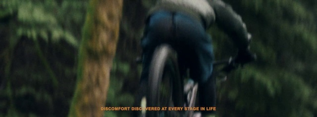 Video Reference: Natural environment, Jungle, Downhill mountain biking, Tree, Forest, Organism, Mountain biking, Wildlife, Adaptation, Vehicle, Blurry, Man, Standing, Street, Riding, Red, Bird, Screenshot