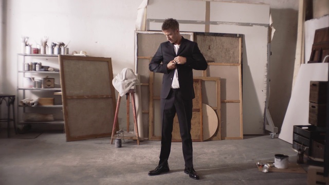 Video Reference: Standing, Snapshot, Furniture, Indoor, Person, Man, Holding, Suit, Room, Woman, Young, Black, Front, Living, Table, Wearing, Computer, Laptop, Walking, Board, Suitcase, Doing, White, Floor, Clothing, Trousers, Footwear