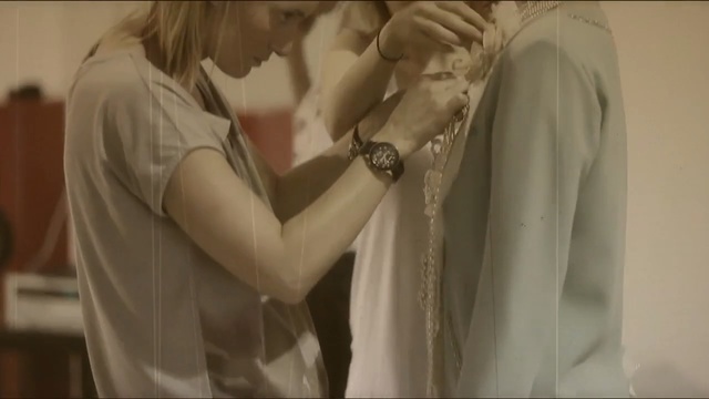Video Reference: Photograph, Lady, Snapshot, Shoulder, Romance, Fashion, Love, Blond, Interaction, Photography, Person, Indoor, Man, Clothing, Woman, Mirror, White, Photo, Looking, Standing, Dress, Wearing, Holding, Front, Wedding, Black, Young, Hair, Shirt, Suit, Cutting, Sink, Wall, Wedding dress, Bride, Fashion accessory, Ivory