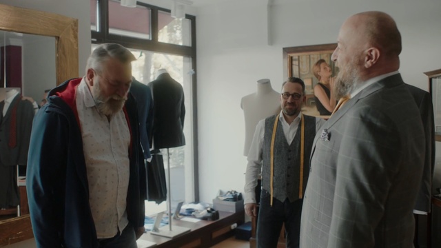 Video Reference: Event, Exhibition, Vernissage, Tourist attraction, Art, Suit, Collection, Visual arts, Art exhibition, Person, Indoor, Standing, Man, Kitchen, Looking, Holding, Preparing, People, Front, Counter, Food, Wine, Woman, Table, Room, Group, Cooking, Shirt, Cake, Living, Remote, Luggage, Wall, Clothing, Human face