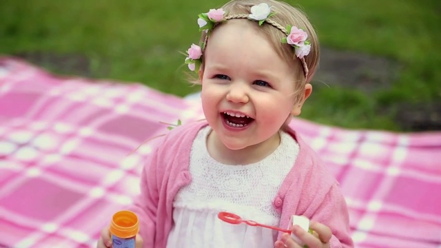 Video Reference: Child, Face, Facial expression, Hair accessory, Toddler, Pink, Skin, Head, Smile, Headband, Person, Grass, Little, Outdoor, Table, Sitting, Small, Holding, Girl, Food, Baby, Young, Plate, Front, Plastic, Mouth, Close, Smiling, Wearing, Cake, Red, Yellow, Playing, Colorful, Frisbee, Hat, Eating, White, Umbrella, Standing, Human face, Clothing, Cute, Flower, Fashion accessory, Dessert