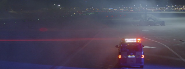 Video Reference: Sky, Light, Atmospheric phenomenon, Mode of transport, Transport, Atmosphere, Lighting, Night, Automotive lighting, Cloud, Outdoor, Road, Water, Traffic, Highway, Car, Driving, City, Plane, Red, Street, Stopped, Large, Truck, Busy, Green, White, Sunset, Airplane, Way, Fog