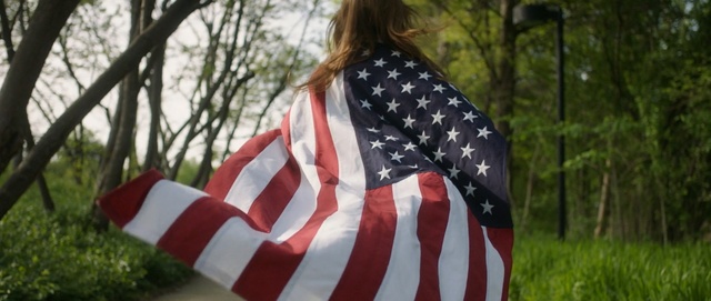 Video Reference: flag, flag of the united states, tree, outerwear, grass, pattern, design, plant, girl, Person