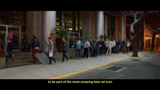 Video Reference: People, Pedestrian, Snapshot, Crowd, Town, Human settlement, Public space, Standing, Street, Urban area, Building, Walking, Sidewalk, Woman, Man, Young, City, Group, Luggage, Platform, Table, Room, Holding, Large, Yellow, Doing, Riding, White, Night, Person, Clothing, Footwear, Screenshot