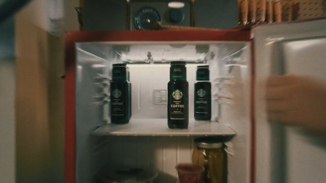 Video Reference: refrigerator, fridge, shelf, bottles, jars, coffee, beverage, kitchen, open door, interior, close-up, blurred, food storage