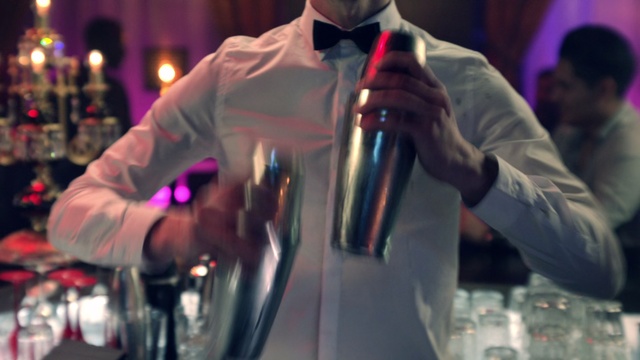 Video Reference: Alcohol, Drink, Bartender, Glass, Distilled beverage, Wine, Wine glass, Person, Indoor, Man, Front, Table, Looking, Woman, Holding, Glasses, Wearing, Drinking, Mirror, Standing, Shirt, Birthday, Kitchen, Pink, Red, People, Room, Bottle, Concert, Soft drink, Clothing