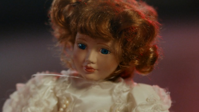 Video Reference: Doll, Hair, Face, Toy, Wig, Head, Cheek, Ringlet, Eye, Lip, Person, Cake, Indoor, Piece, Looking, Food, Slice, Little, Holding, Table, Eating, Sitting, Young, Bite, Birthday, Close, White, Mouth, Boy, Woman, Man, Red, Pizza, Wedding, Shirt, Toddler, Human face, Baby, Girl, Clothing