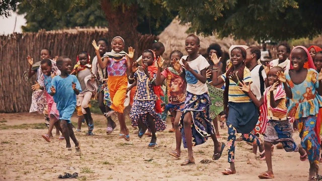 Video Reference: People, Youth, Community, Tribe, Fun, Adaptation, Crowd, Event, Recreation, Child, Person, Outdoor, Sport, Group, Young, Playing, Beach, Man, Soccer, Boy, Standing, Holding, Front, Girl, Large, Ball, Brown, Sand, Woman, Player, Game, White, Field, Frisbee, Dirt, Ground, Tree, Clothing, Dance, Smile, Footwear, Sandy, Several