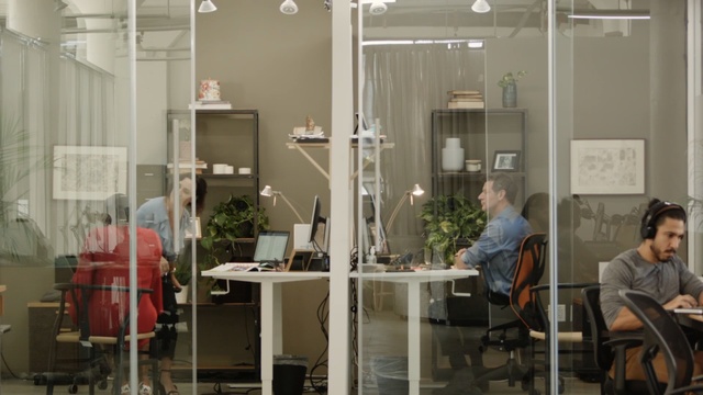 Video Reference: Furniture, Room, Interior design, Building, Table, Office, Architecture, Window, Chair, Glass, Indoor, Person, Sitting, Computer, Laptop, Man, Woman, Using, Small, Young, Dining, People, Kitchen, Group, Black, White, Desk, Restaurant, Living, Standing, Office building, Floor, Shelf, Clothing