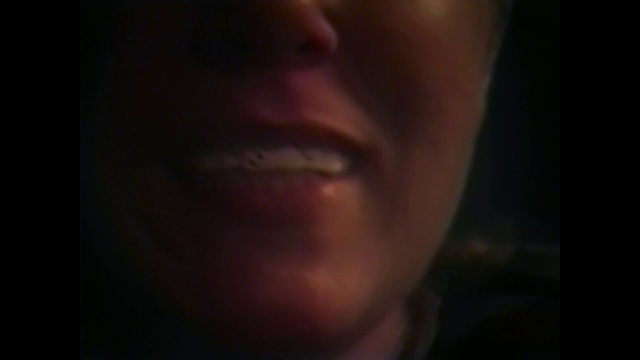 Video Reference: Face, Lip, Nose, Cheek, Chin, Eyebrow, Black, Forehead, Skin, Facial expression, Person, Looking, Indoor, Man, Front, Wearing, Dark, Holding, Young, Shirt, Camera, Close, Suit, Smiling, Red, Food, Standing, Room, White, Teeth, Blurry, Brushing, Blue, Human face, Selfie, Eyes, Portrait, Jaw, Staring