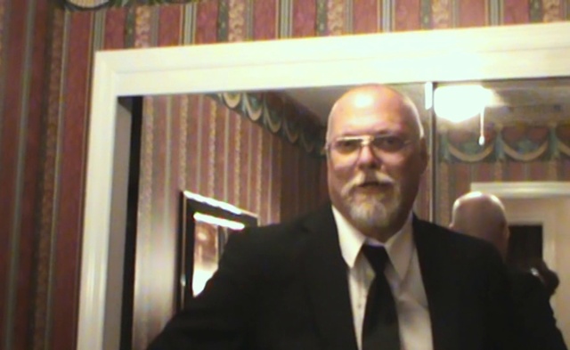 Video Reference: Smile, Tie, Dress shirt, Collar, Beard, Blazer, Suit, Formal wear, Event, Wood