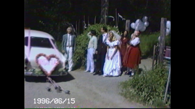 Video Reference: Photograph, Ceremony, Pink, Wedding, Snapshot, Bride, Male, Dress, Groom, Event, Outdoor, Road, Man, Photo, Street, Standing, Young, Front, Sign, Boy, Holding, Woman, Walking, Riding, Board, Wearing, Jumping, Playing, White, People, Player, Ball, Air, Doing, Bus, Person, Clothing, Text, Wedding dress