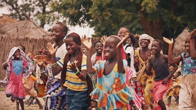 Video Reference: People, Tribe, Community, Adaptation, Event, Crowd, Fun, Tradition, Festival, Child, Person, Outdoor, Dancer, Group, Holding, Walking, Standing, Street, Young, Man, Carrying, Large, Playing, Riding, Boy, Court, Woman, Elephant, Water, Frisbee, Clothing, Tree, Smile, Human face, Girl, Dance, Sport