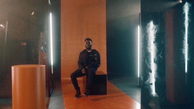 Video Reference: studio, black man, sit, forms, form, room, lights, Person