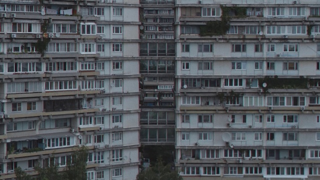Video Reference: Residential area, Building, Urban area, Tower block, Condominium, Architecture, Apartment, Neighbourhood, Human settlement, Metropolitan area, Outdoor, Water, Large, Tall, City, Sitting, Library, Many, Standing, Group, Row, Young, People, Street, Man, Bus, Room, Window, Apartment building, Skyscraper, House, Sky