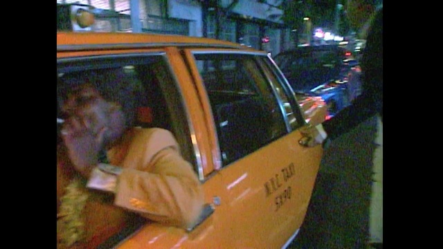 Video Reference: Vehicle, Car, Mode of transport, Taxi, Vehicle door, Automotive exterior, Photography, Automotive window part, Building, Outdoor, Street, Sitting, Man, Yellow, Dog, Orange, Standing, Night, Side, Door, City, Woman, Holding, Sign, Cat, Parked, Phone, Mirror, Young, White, Pizza, Riding, Truck, Fire, Land vehicle, Wheel, Transport, Text, Auto part