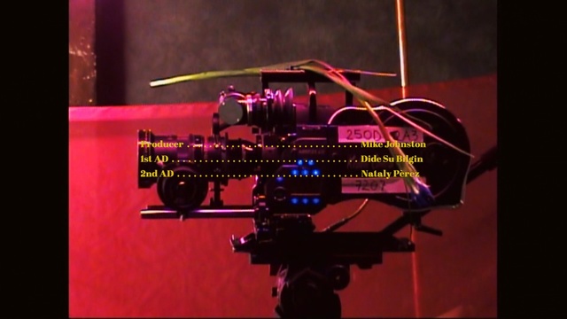 Video Reference: Font, Photography, Room, Space, Magenta, Indoor, Sitting, Computer, Dark, Table, Lit, Laptop, Screen, Desk, Black, Light, Monitor, Keyboard, Phone, Red, Television, Mouse, Purple, Blue, Text, Music