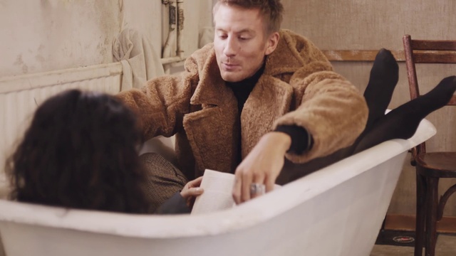 Video Reference: Fur, Bathtub, Fur clothing, Person, Indoor, Sitting, Thing, Table, Cat, Looking, Front, Man, Young, Woman, Brown, Using, Water, White, Holding, Sink, Tub, Playing, Wall, Human face, Clothing, Basket