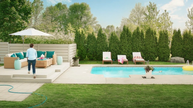 Video Reference: swimming pool, property, leisure, backyard, yard, estate, grass, outdoor furniture, house, sunlounger, Person