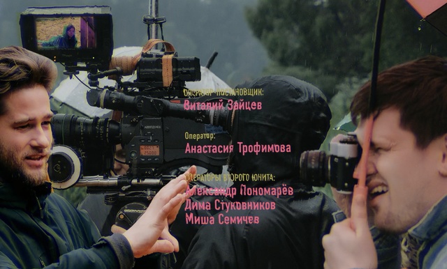 Video Reference: Cinematographer, Camera operator, Filmmaking, Videographer, Journalist, Movie, Photography, Film crew, Photo caption, Person, Man, Holding, Looking, Young, Standing, Front, Woman, People, Sitting, Table, Hair, Wearing, Phone, Group, Talking, Train, Camera, Rifle, Weapon, Tripod, Gun, Optical instrument, Firearm