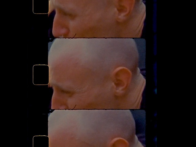 Video Reference: Face, Ear, Nose, Cheek, Chin, Skin, Neck, Head, Forehead, Jaw, Person, Man, Looking, Front, Wearing, Young, Piece, Glasses, Shirt, Eating, Sitting, Pizza, Food, Standing, Holding, Hot, Orange, Table, Laptop, Screen, Bite, Teeth, Hotdog, Human face, Baby, Toddler, Screenshot, Staring