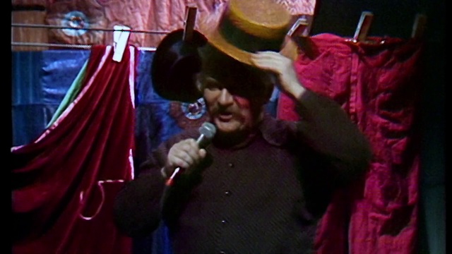 Video Reference: People, Purple, Magenta, Performance, Pink, Fun, Lady, Snapshot, Music, Performance art, Person, Indoor, Man, Red, Holding, Looking, Wearing, Woman, Front, Cellphone, Phone, Glasses, Mirror, Hat, Table, Hair, Mouth, Using, Teeth, Standing, Young, Black, Shirt, Brushing, Room, White, Playing, Human face, Clothing, Concert, Dance, Smile