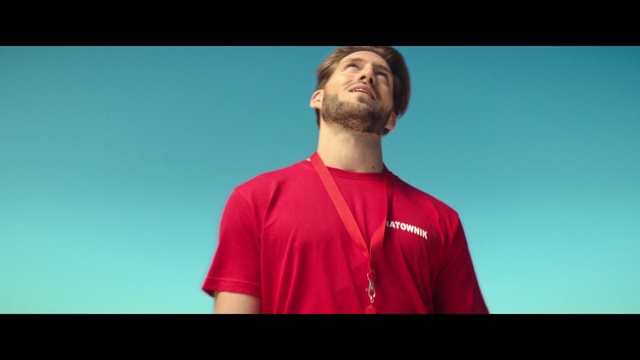 Video Reference: Facial expression, Red, Shoulder, Facial hair, T-shirt, Chin, Cheek, Standing, Arm, Joint