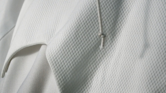 Video Reference: white, clothes hanger, shoulder, outerwear, sleeve, textile, line, collar, button, design
