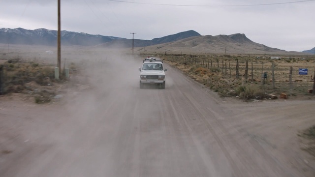 Video Reference: road, car, dirt road, transport, mountainous landforms, mode of transport, road trip, infrastructure, dust, asphalt