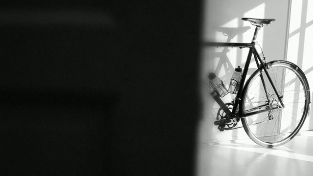 Video Reference: bicycle, land vehicle, black and white, road bicycle, photography, bicycle frame, monochrome photography, bicycle wheel, bicycle part, monochrome, Person