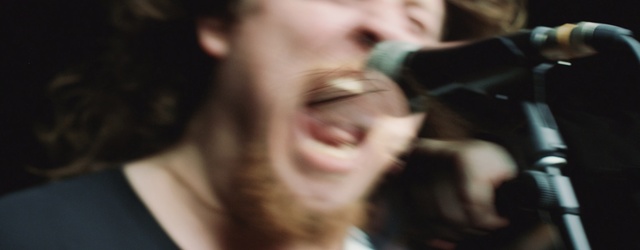 Video Reference: Face, Hair, Facial expression, Nose, Smile, Head, Chin, Cheek, Eyebrow, Forehead, Person, Indoor, Man, Looking, Woman, Camera, Sitting, Front, Smiling, Glasses, Cat, Suit, Wearing, Holding, Black, Young, Close, Hat, White, Red, Mouth, Standing, People, Human face, Blur, Spectacles