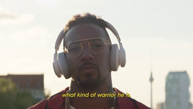 Video Reference: Headphones, Audio equipment, Personal protective equipment, Eyewear, Gadget, Technology, Glasses, Electronic device, Temple, Hearing, Outdoor, Person, Building, Man, Front, Wearing, Looking, Holding, Standing, Red, White, Large, Street, Field, Yellow, Sign, Stop, Water, Hat, Woman, Riding, Shirt, City, Sky, Goggles, Human face, Spectacles