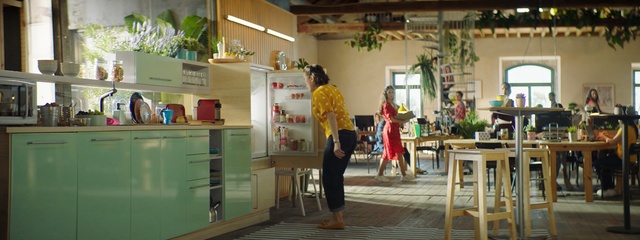 Video Reference: Snapshot, Fun, Building, Temple, Plant, Leisure, Houseplant, Person, Indoor, Table, Chair, Kitchen, Room, Window, Area, Wooden, Dining, Living, Computer, Small, Sitting, Desk, Green, Food, Woman, Counter, Furniture, Laptop, White, Standing, Man, Large, People, Dog, Stove, Floor, Clothing, Footwear, Text, Cluttered