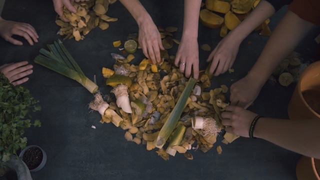 Video Reference: Food, Dish, Cuisine, Vegetarian food, Plant, Person, Cutting, Indoor, Cut, Knife, Table, Woman, Cake, Kitchen, People, Young, Group, Banana, Plate, Board, Man, Holding, Black, Large, Standing, Eating, White, Doing, Vegetable