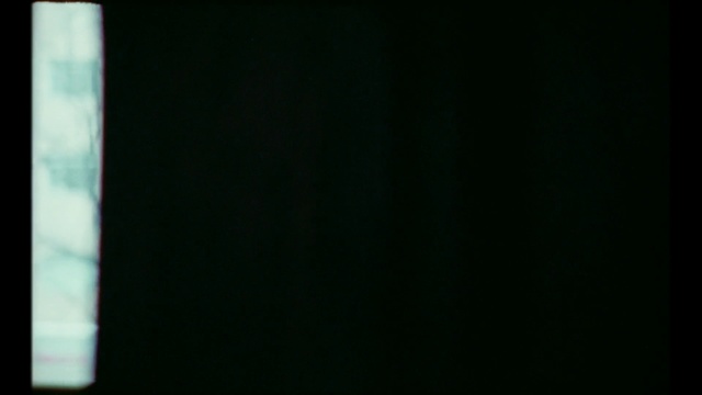 Video Reference: Black, Green, Blue, Darkness, Light, Atmosphere, Sky, Photography, Indoor, Sitting, Monitor, Screen, Table, Television, Laptop, Computer, White, Glass, Large, Man, Close, Dark, Holding, Red, Food, Room, Keyboard, Desk, Vase, Standing, Cat, Text