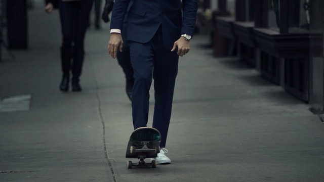 Video Reference: footwear, infrastructure, shoe, suit, jeans, road, leg, joint, street, trousers, Person
