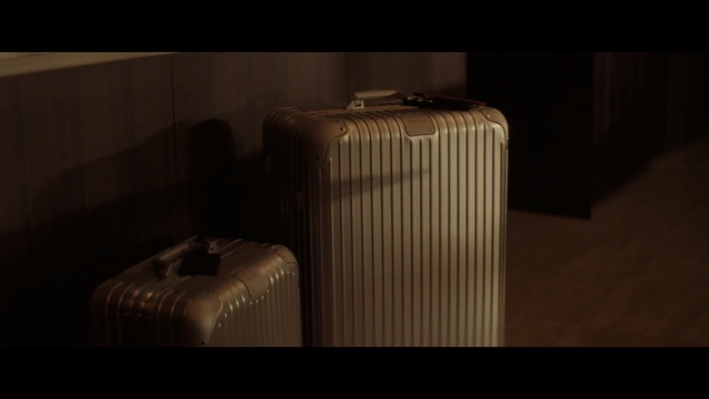 Video Reference: Lighting, Brown, Furniture, Table, Photography, Darkness, Room, Architecture, Still life photography, Baggage, Indoor, Sitting, Suitcase, Luggage, Front, Box, Black, White, Large, Standing, Cat