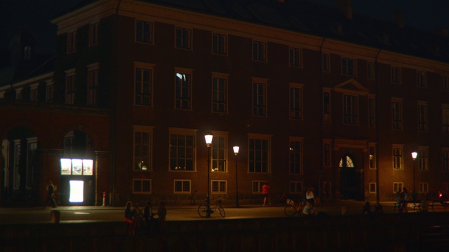 Video Reference: Night, Light, Lighting, Architecture, Building, Darkness, Facade, Home, Midnight, Evening, Outdoor, Street, Large, Sitting, Front, City, Lit, Dark, Man, Standing, View, Water, Clock, Bus, Red, Tall, Sign, Table, Tower, Parked, Traffic, Riding, Room, Bicycle, House, Government building