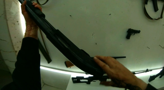 Video Reference: Windshield, Windscreen wiper, Firearm, Automotive window part, Auto part, Glass, Automotive exterior, Bumper, Indoor, Man, Hand, Table, Knife, Hanging, Old, White, Cutting, Large, Holding, Pair, Cut, Plane, Room, Weapon, Office supplies, Tool, Gun